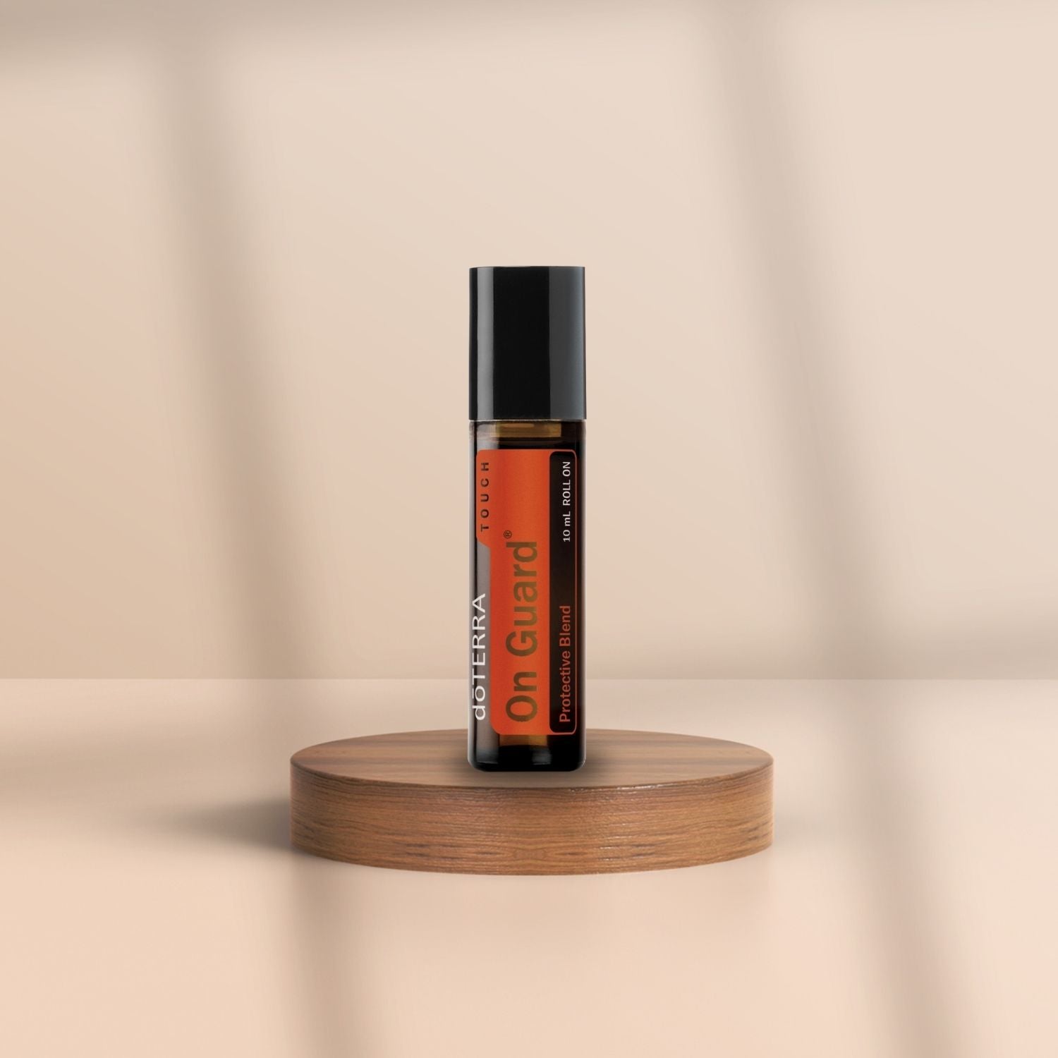 Braune Roll-On-Flasche von doTERRA On Guard auf Holzpodest, vor neutralem Hintergrund.