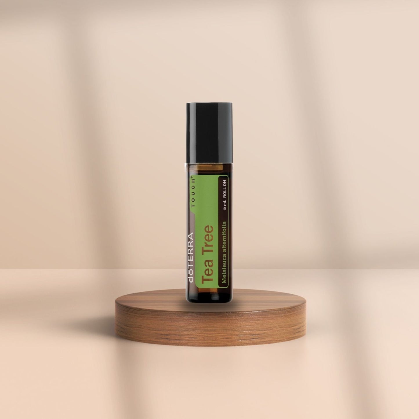 Roll-On Flasche von doTERRA Tea Tree Touch mit 10 ml ätherischem Teebaumöl auf Holzpodest – beruhigend, klärend, natürlich