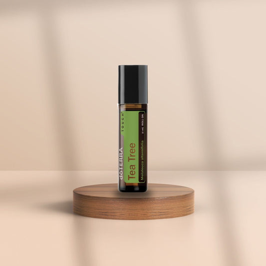 Roll-On Flasche von doTERRA Tea Tree Touch mit 10 ml ätherischem Teebaumöl auf Holzpodest – beruhigend, klärend, natürlich